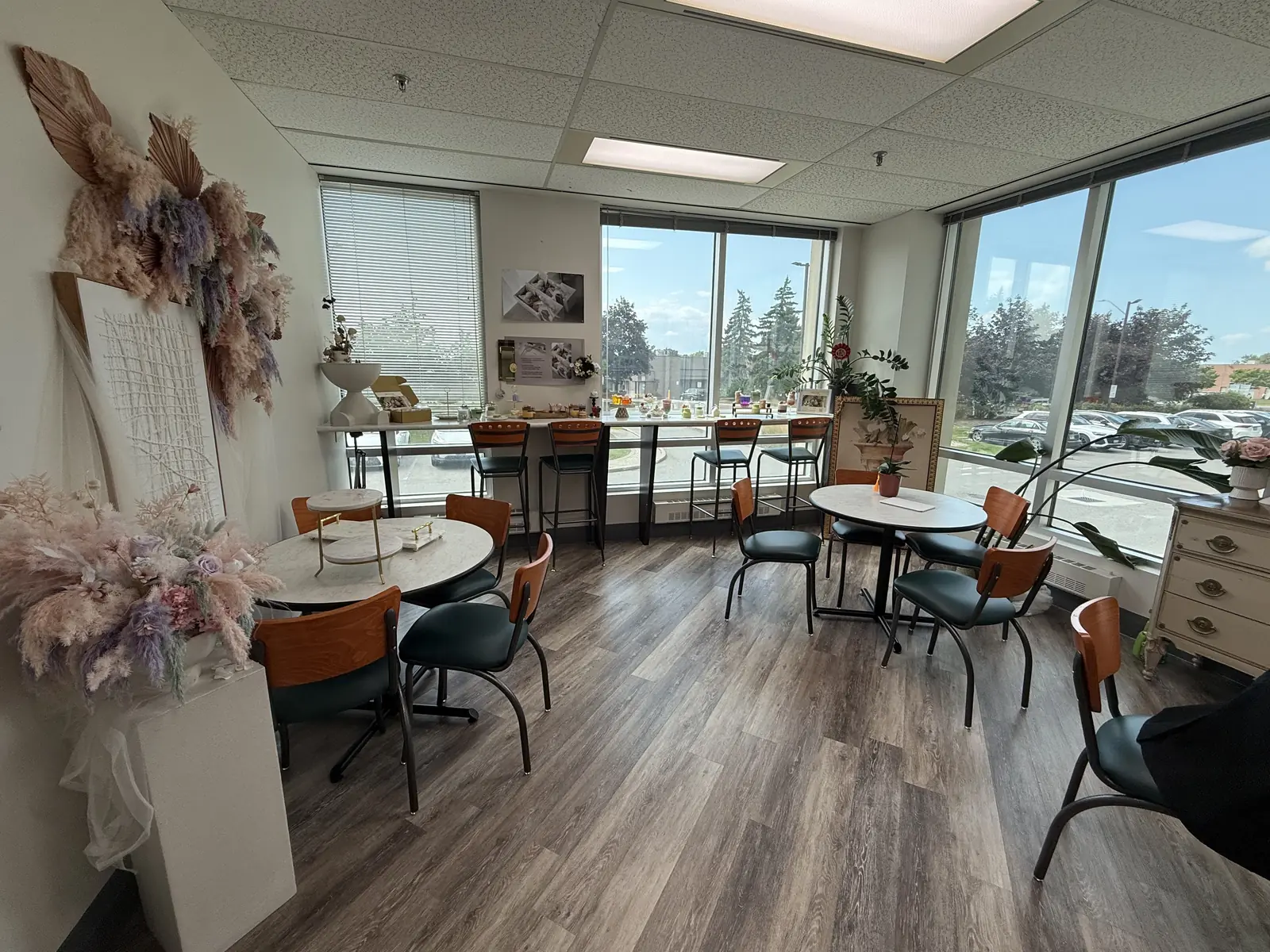 The lounge at Artistry Clinic, with marble tables, dried floral installations, and a long window counter overlooking the street.